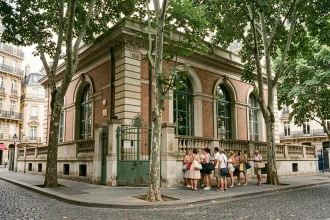 Façade historique de la piscine de la Butte-aux-Cailles dans le 13e arrondissement de Paris avec une file d'attente de baigneurs
