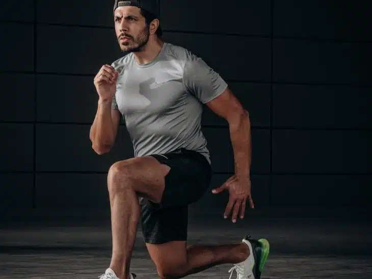 man in white crew neck t-shirt and black shorts sitting on floor